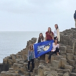 students at giants causeway with banner